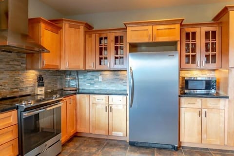 The spacious kitchen is complete with granite countertops, stainless steel appliances, and abundant cabinet and counter space ready with everything you need to whip up a meal for your group.