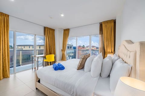 Wake up to colorful rooftops and palm trees from your bright, sun-filled bedroom. Crisp linens and plush towels await you in this serene space with golden drapes framing city views.