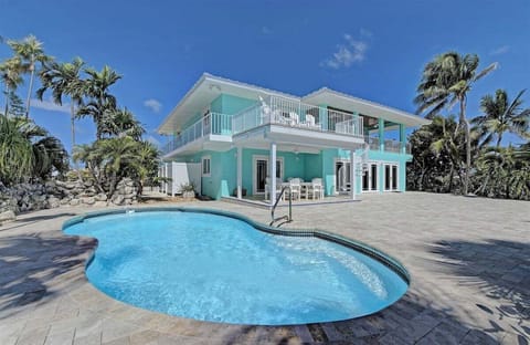 Stunning canal front retreat featuring a private pool, expansive outdoor living spaces, and breathtaking Florida Keys waterfront views.