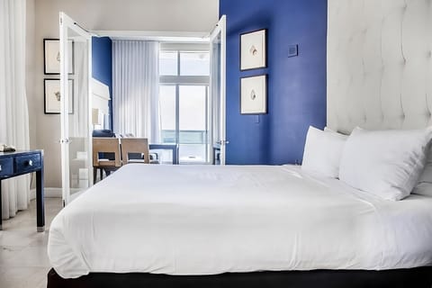 Unwind in crisp linens with breezy balcony daylight.