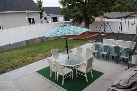 Patio and backyard with fence, dining area including BBQ grill and firepit.