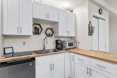 Galley kitchen with electric stove top, microwave, mini fridge