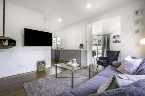 Open plan lounge area with fireplace, split system hearting and cooling and Smart TV