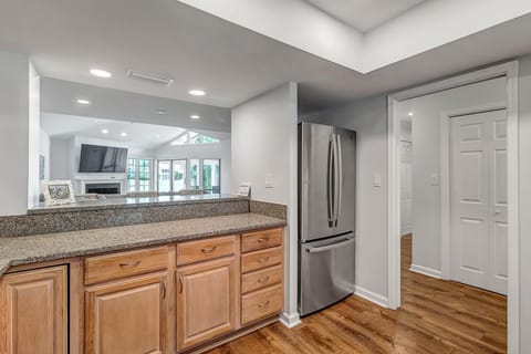 - Stainless steel fridge and plenty of counter space make this kitchen guest ready
- Pass through view keeps kitchen connected to the living room and TV zone
- Recessed lighting and wood floors enhance the open, airy layout of the home