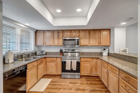 - Fully equipped kitchen with stainless steel appliances and granite countertops
- Natural wood cabinets offer plenty of storage for longer, relaxed stays
- Overhead lighting and wide window make meal prep bright and enjoyable