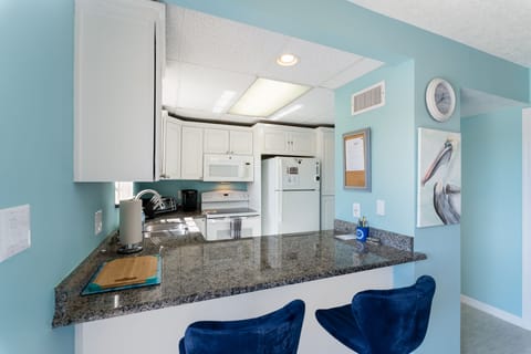 Fully functional kitchen with bar stools.