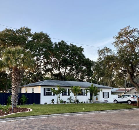 Beautiful triplex home on red brick road with waterfront visible from yard.