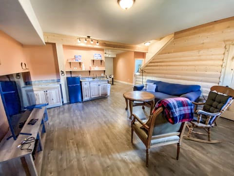 The Entertainment Room features cozy seating around a smart TV, a wet bar with mini fridge, toys and games for all ages