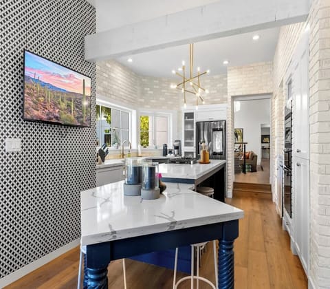 Modern kitchen with marble countertops and a geometric accent wall.