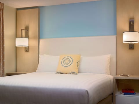 Sink into crisp linens beneath calming, designer-lit headboard.