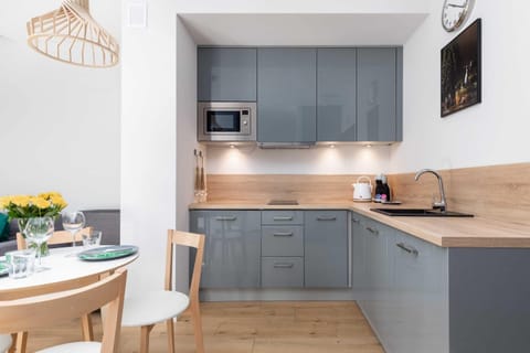 A modern kitchen with gray cabinetry, wood countertops, and built-in appliances, designed for efficiency and style.