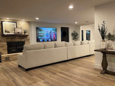 Family Room with 16 foot couch, 85" TV and wood burning fireplace