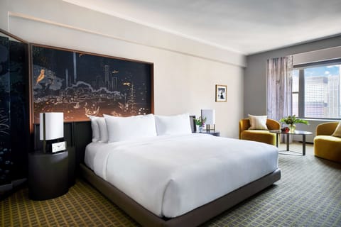 Drift off in a serene king bed with skyline backdrop.