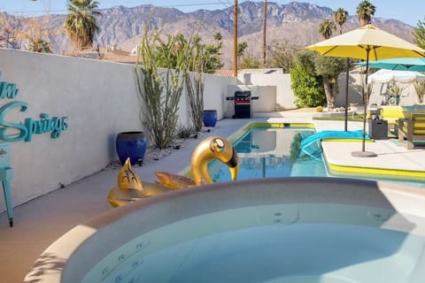 Sunny backyard with pool, spa, gas grill, and mountain backdrop — the shot you screenshot before you book