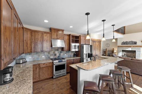 Full size kitchen with granite countertops, high end stainless steel appliances, and breakfast bar for additional seating