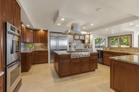 Spacious kitchen with ample breakfast bar seating, center island, and stainless steel appliances
