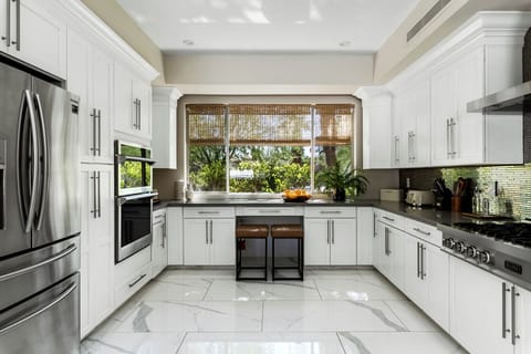 A bright white kitchen with sleek metallic appliances for a clean, modern feel.