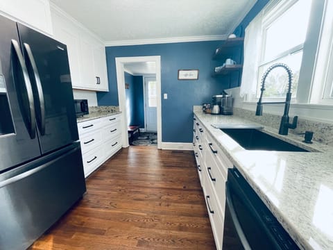 Full kitchen with large basin sink, french door refrigerator, stove and more.