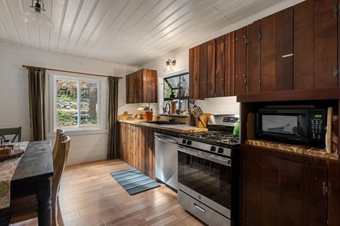 Rustic wood kitchen with a dishwasher and dining table, perfect for easy meals together.