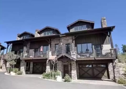 Stunning stone and timber mountain home with spacious balconies and modern architecture in a scenic hillside setting.