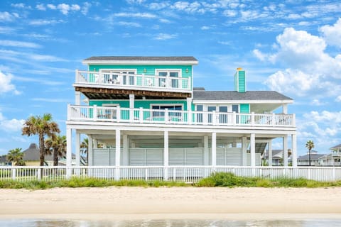 Beachfront Galveston vacation home with large wraparound deck, elevated design, and direct beach access