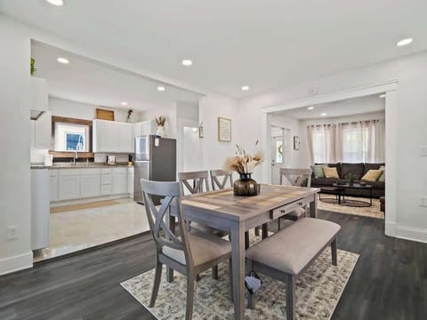 Bright open dining area w/ table, bench seating & view into the kitchen