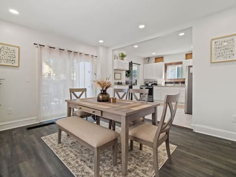 Bright dining area with seating for six plus a bench - Open flow to kitchen with modern appliances and décor - Perfect for shared meals and gathering together