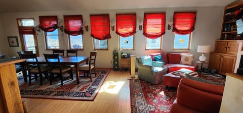 Open living area with living room, dining room, and door to the deck.