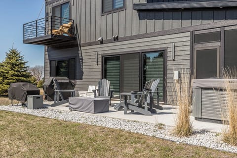 Outdoor seating with propane firepit, gas grill, and hot tub with lake view