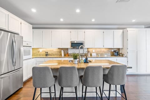 A spacious, fully-equipped kitchen with a full view and sleek bar stools—perfect for cooking, chatting, and entertaining!