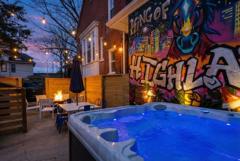 Soak your stress away in this amazing glowing hot tub right next to the cozy fire pit. You will absolutely love the cool urban graffiti wall lighting up your private outdoor space.