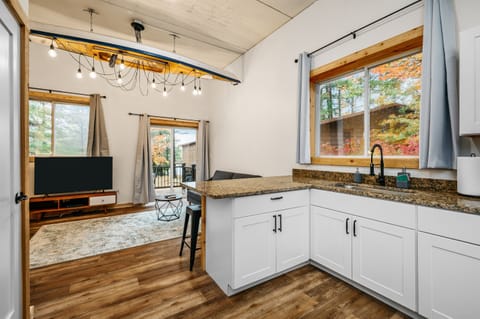 Bright and inviting space with sleek decor, a kayak-shaped light, and autumn views!