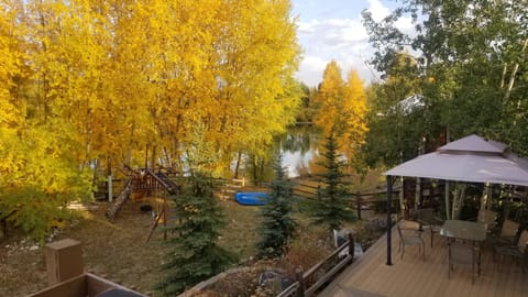 Beautiful backyard area features a playset, pond, and large private deck area.