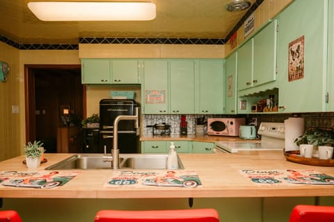 A pastel-perfect kitchen with vintage flair- fully stocked and ready for cooking, snacking, or gathering around the corner.