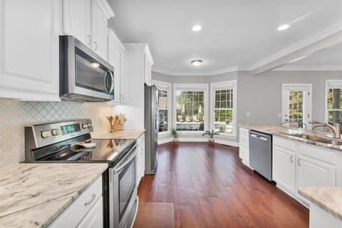 Full kitchen with bay windows.