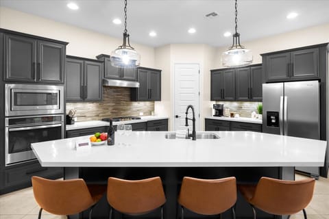 Kitchen | Fully Equipped with High-End Appliances Prepare meals in this sleek kitchen with a gas range, large island, and all essentials.