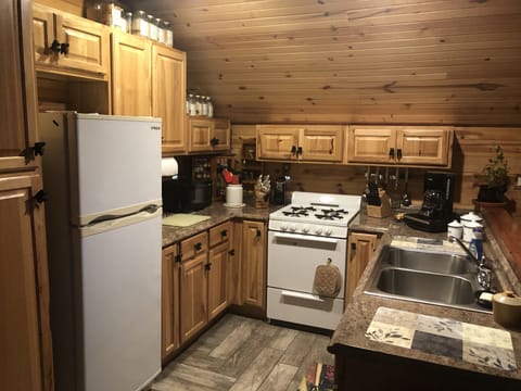 Kitchen area with refrigerator , stove, sink, microwave, toaster, coffee maker.