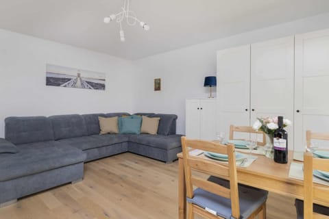 Another view of the living room showcasing the gray sofa and the dining area.
