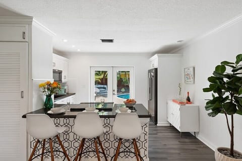 HAVE A QUICK SEAT OR MEAL IN THE BAR SEATING OVERLOOKING THE KITCHEN AND POOL AREA