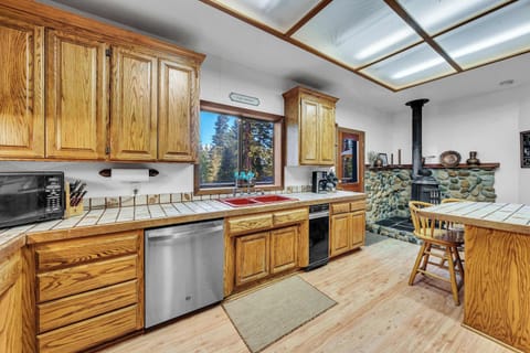 Kitchen: Drip coffee maker, small fireplace, cooking utensils, tableware, bar seating for 4