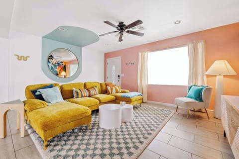 Bright living room w/ plush sectional, playful colors, & cozy seating for lounging together.