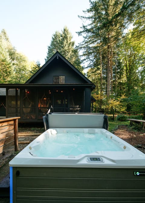 The hot tub is right outside the screened in porch in the backyard.