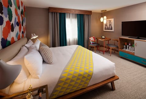 Unwind in crisp linens beside vibrant art and warm lighting.