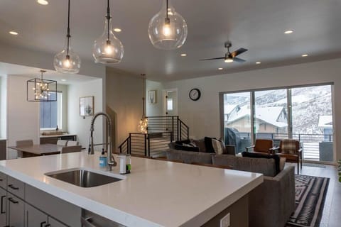 The modernly designed open living space features the living room, kitchen, and dining area and boasts beautiful hardwood floors, exposed wood shelves, a stunning all-white kitchen, and a dining space flooded with natural light.