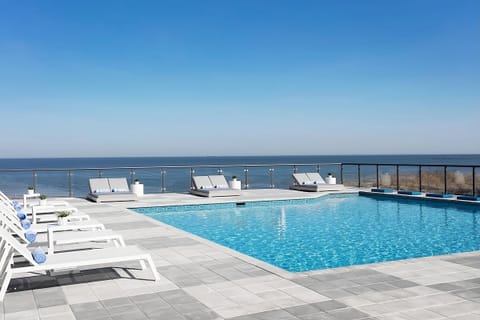 Soak up sun beside the rooftop pool overlooking the sea.