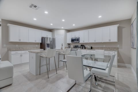 Spacious Dining Area with Adjacent Bar Stools for Additional Seating