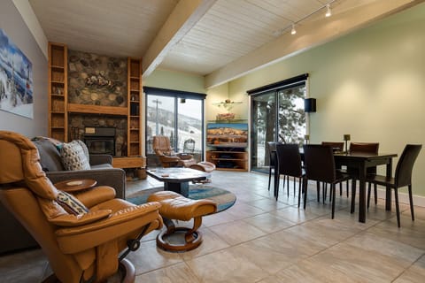 Unwind by your stone fireplace with mountain views streaming through floor-to-ceiling windows in this beautifully appointed living space.