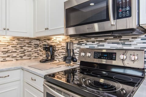 Modern kitchen with sleek appliances and stylish backsplash.