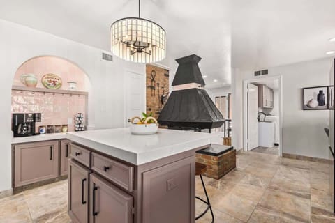 Custom chandelier, colorful accents, and vintage fireplace (aestehtic only) make this kitchen unique.