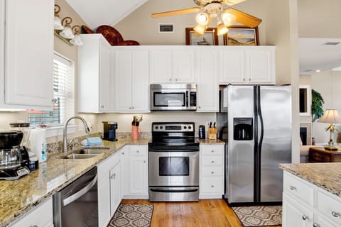 The kitchen is fully equipped and features stone counters and stainless appliances